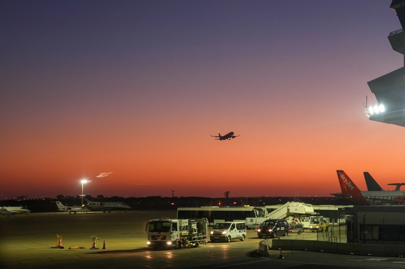 Commercial aircraft departing an airport apron at sunset